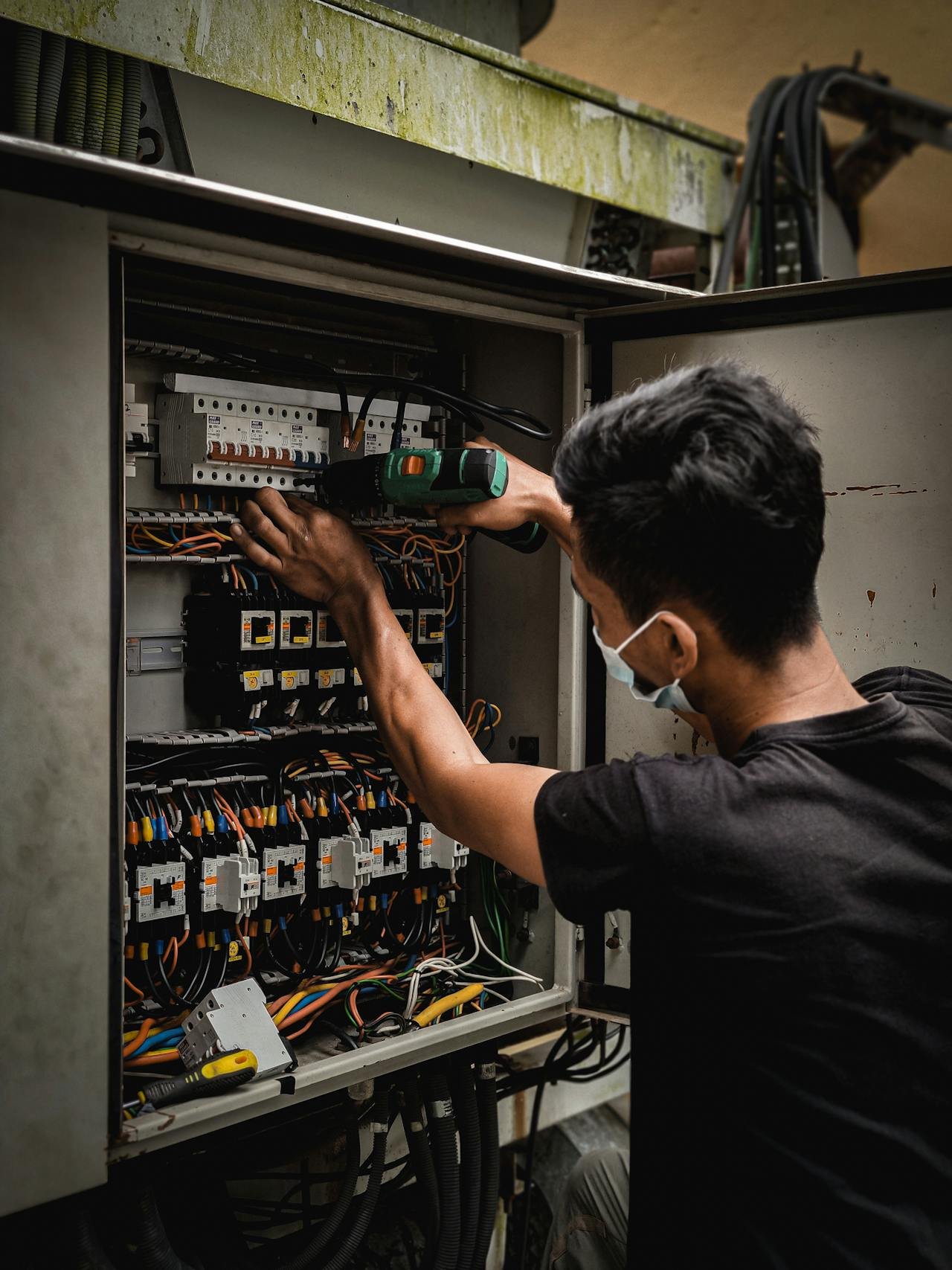 Electrician working on circuit breaker panel for specialty contractor software review